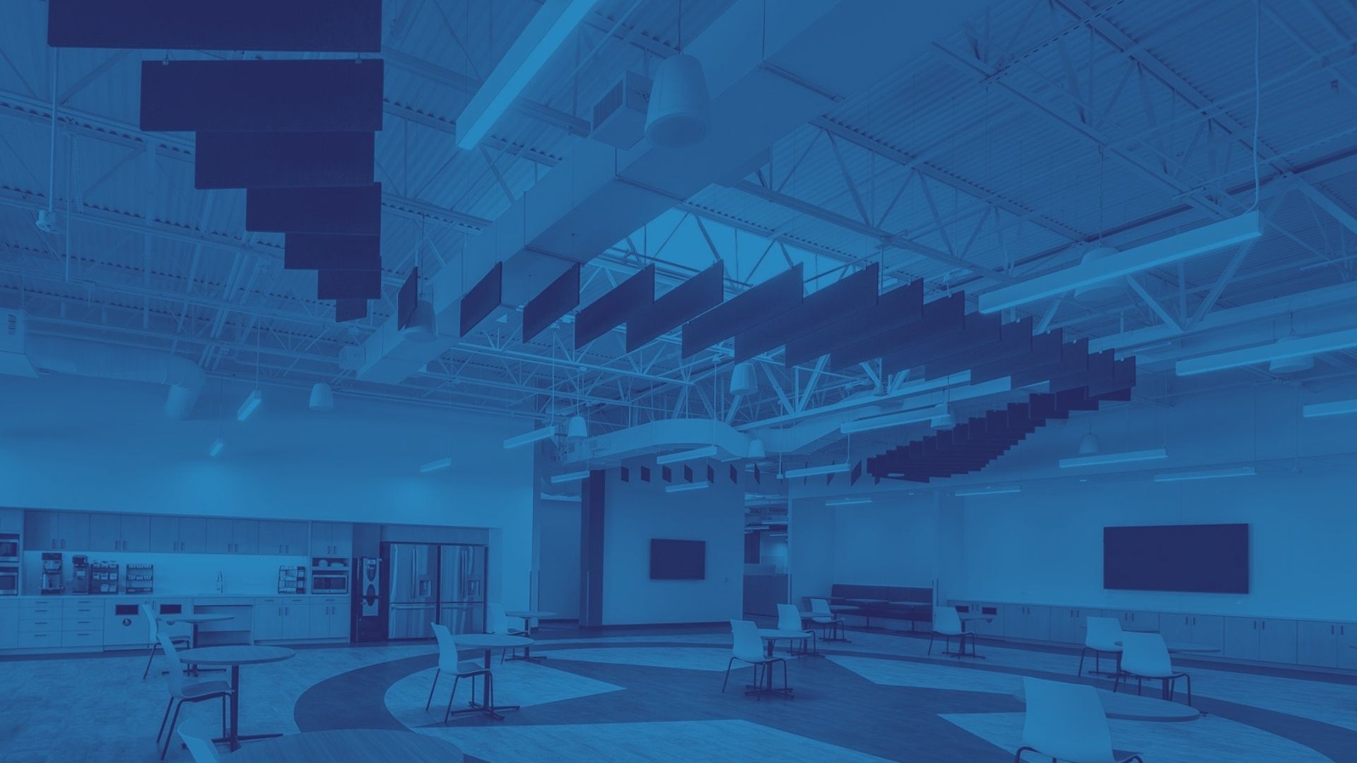 Acoustic baffles hung in a curved ribbon over an open break area